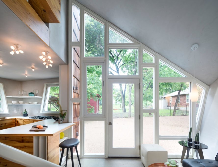 Hive Guesthouse view of kitchen and living room looking out of house through glass wall and door