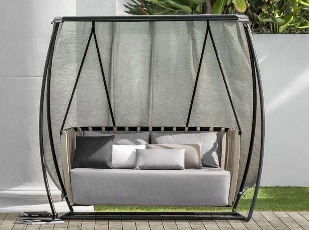 black, teak, and fabric outdoor swing with upholstered cushions and curtains