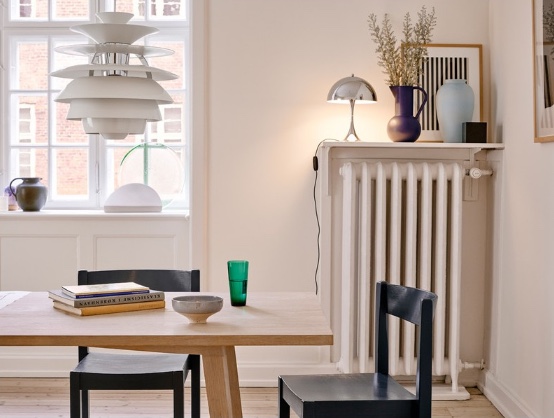 white aluminum pendant hanging above natural wood dining table