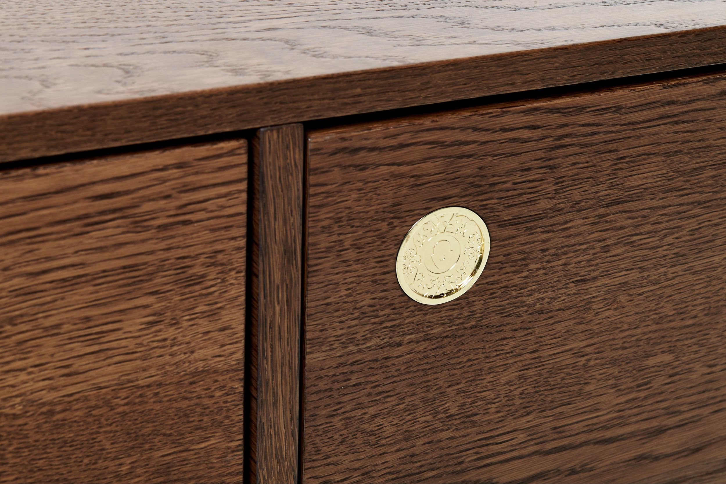 gold medallion detail on oak buffet