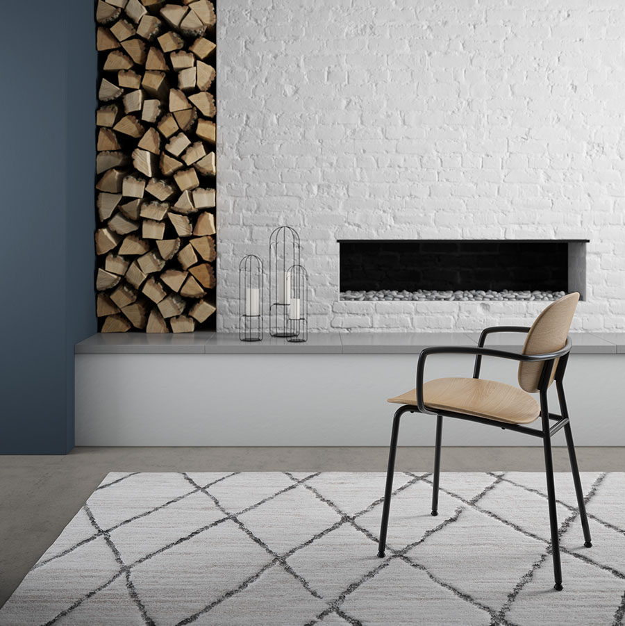 Bryn Chair wood residence in front of fireplace