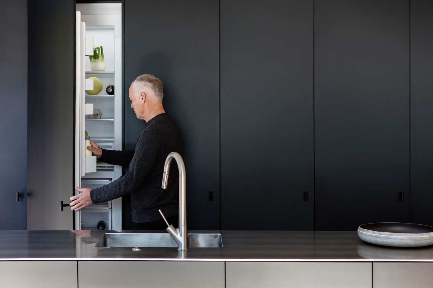 Fisher & Paykel Column Refrigerator charcoal matching cabinetry with man opening door