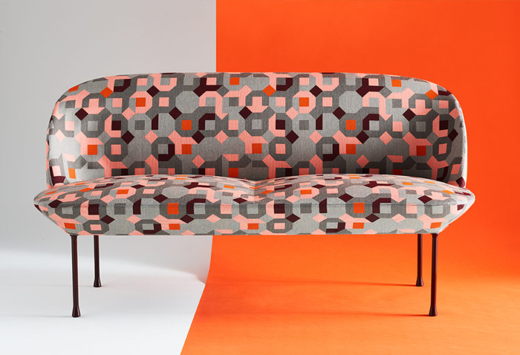 Carnegie Game Theory Fabrics puzzle pattern pink, red, and gray on sofa