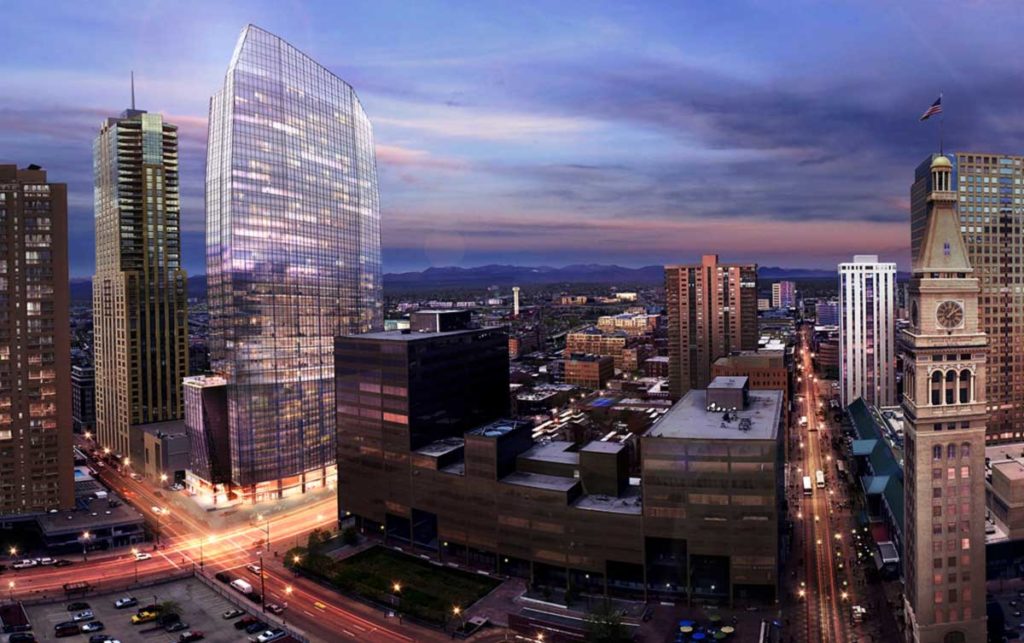 glass curtain wall skyscraper in downtown Denver with moving traffic visible