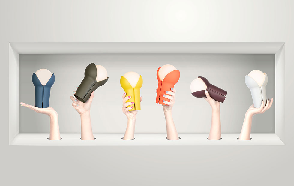 hands holding small colorful cordless lamps