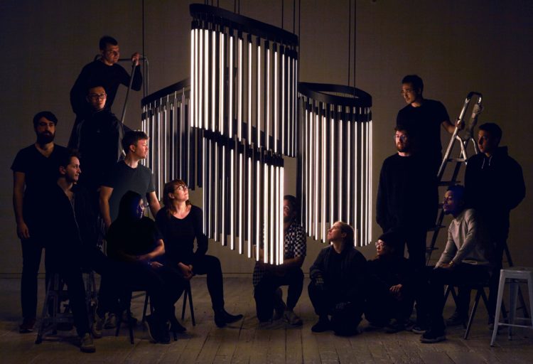 Stickbulb's Chime Chandelier three chandeliers with many people gathered around