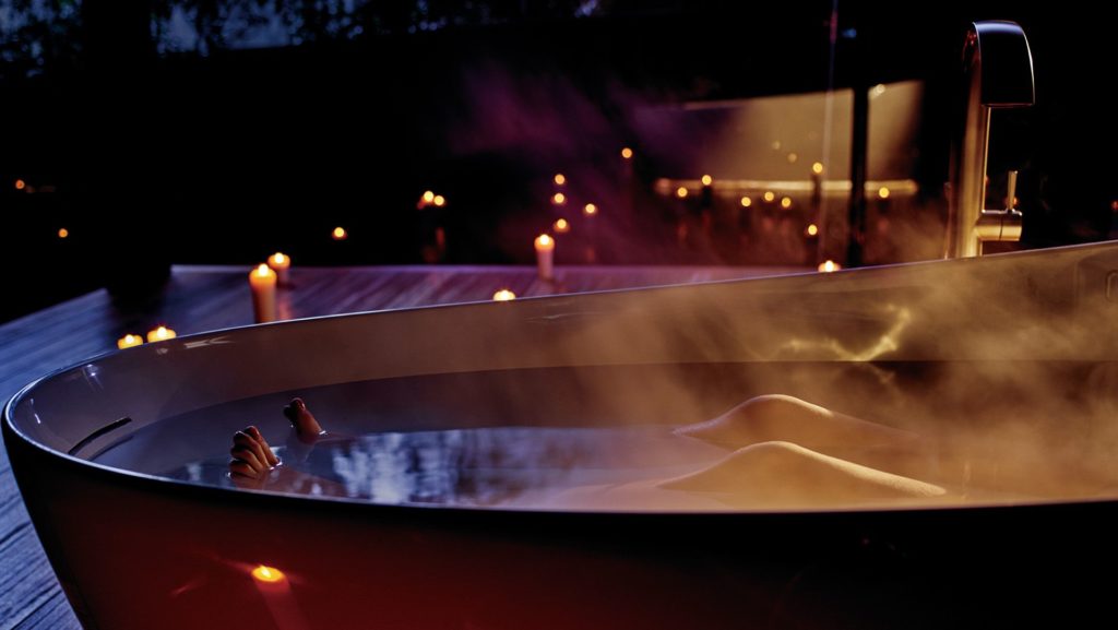 Toto's Zero Dimension tub outside on patio with woman from legs down