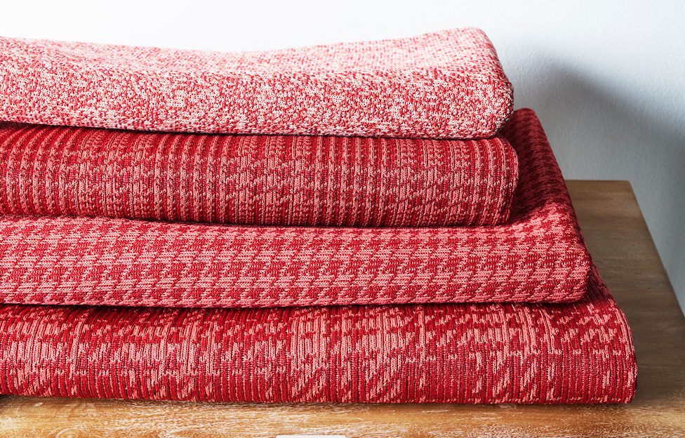 pile of performance fabrics in red patterns