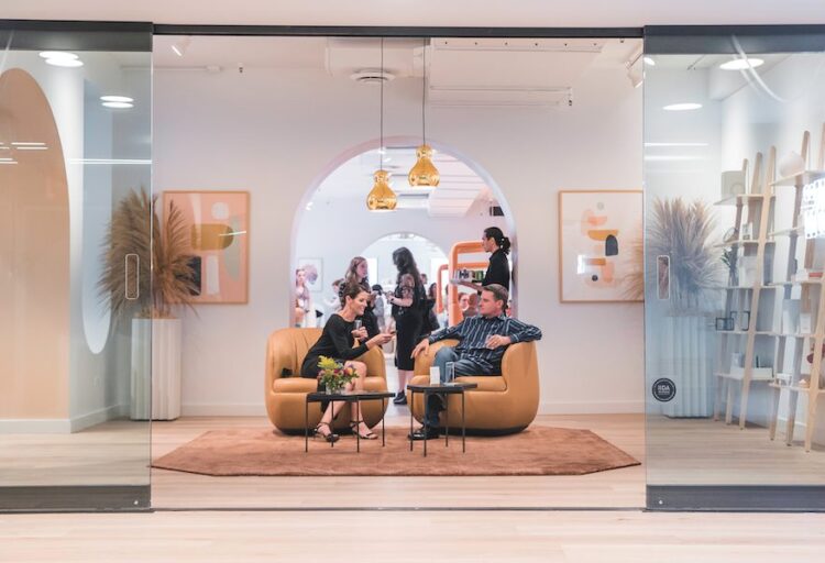 glass doors opening to furniture showroom with two people in leather lounge chairs