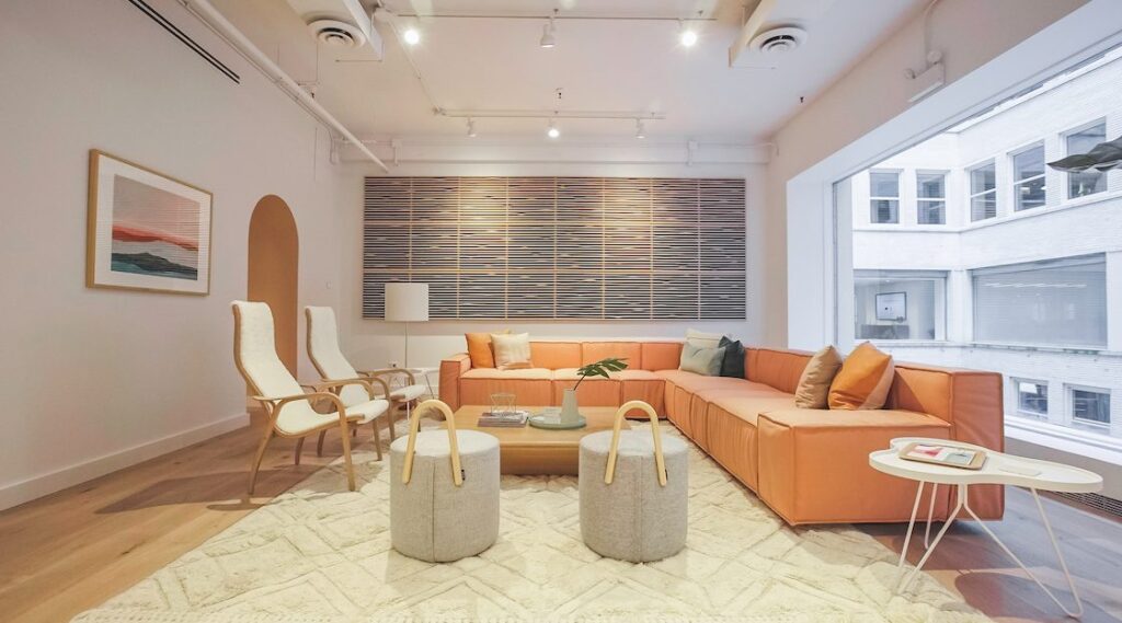 Scandinavian-inspired room with neutrals, wool sectional sofa, and wood-framed upholstered lounge chairs