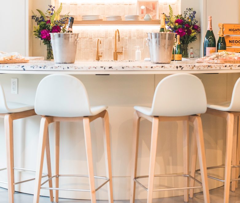 molded white armless barstools with wood base around circular bar