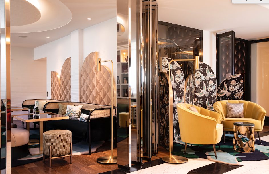 boutique hotel lobby with small guest seating and dining areas in Art Deco style
