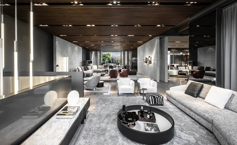 Minotti showroom with modular upholstered sofas, lounge chairs and round coffee table in lacquered wood