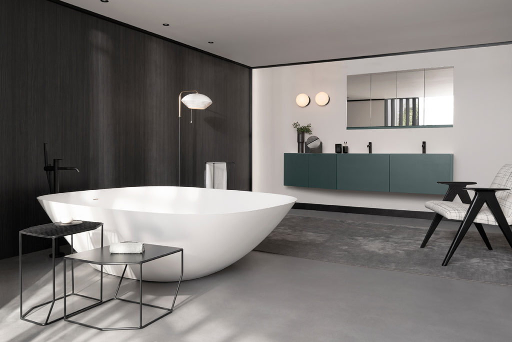 Inbani Forma Collection white tub foreground, green vanity in background