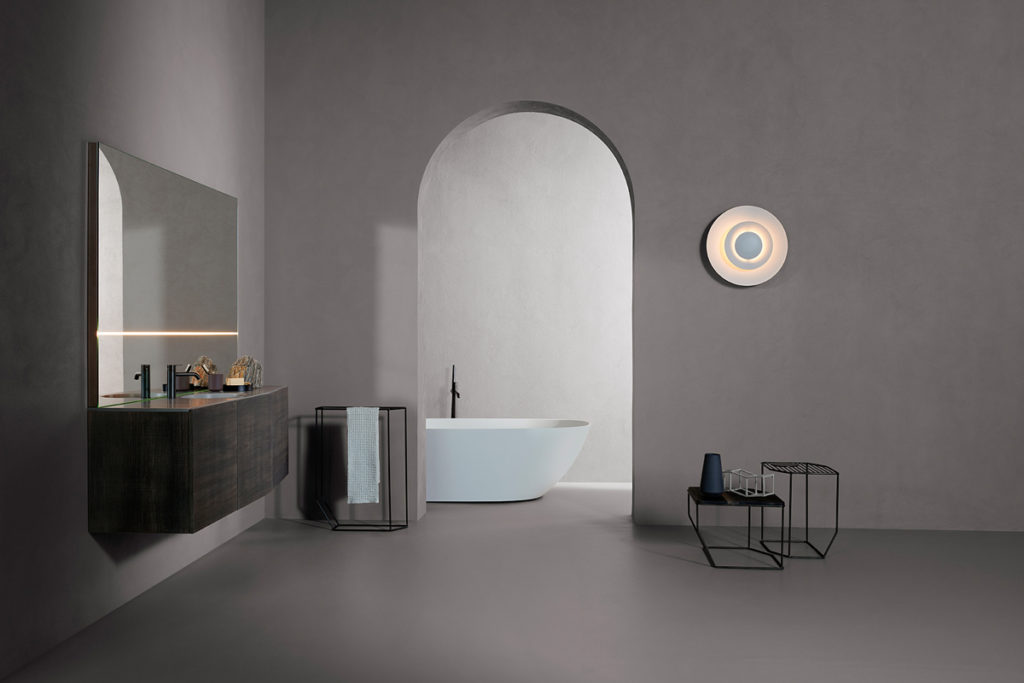 Inbani Forma Collection brown lacquer vanity in foreground white tub iin background
