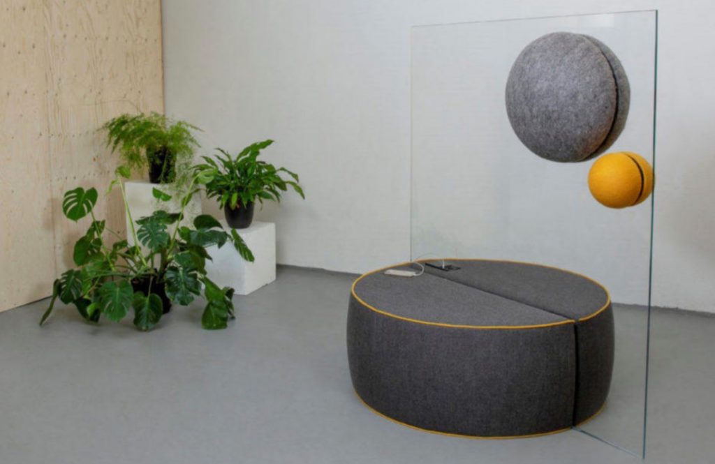 Unika Vaev Kula two units yellow and gray installed on glass partition with gray ottoman beneath