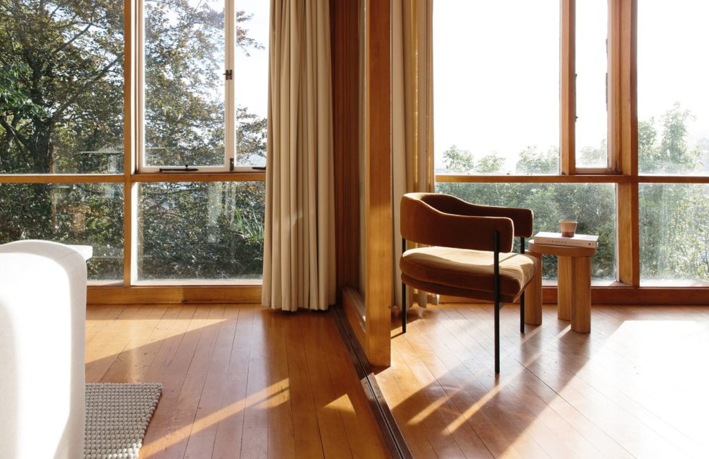 Resident Isabella Chair brown in living room overlooking forest