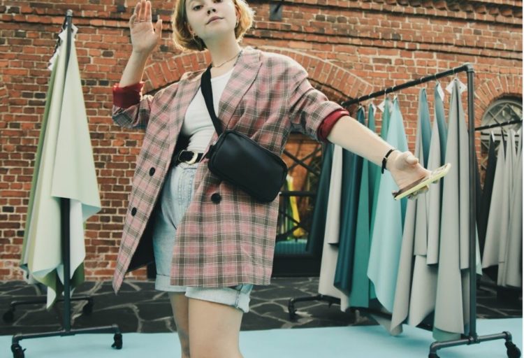 Runway model with handbag with Ultrafabric textile waving with Ultrafabrics samples hanging up in background