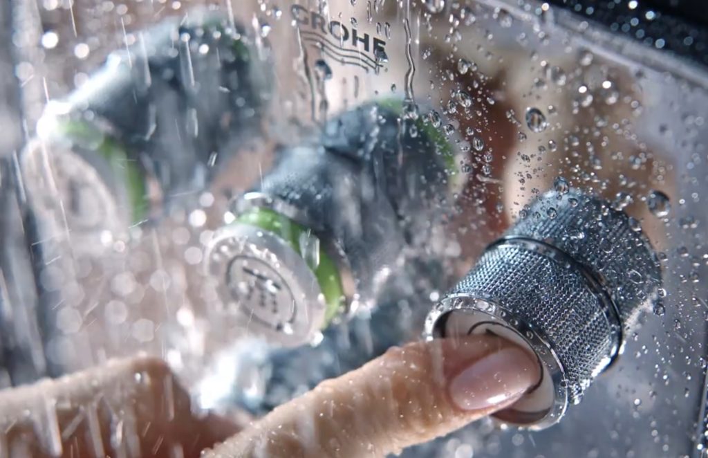 GROHE smart control shown in use with shower and finger pressing one of the buttons
