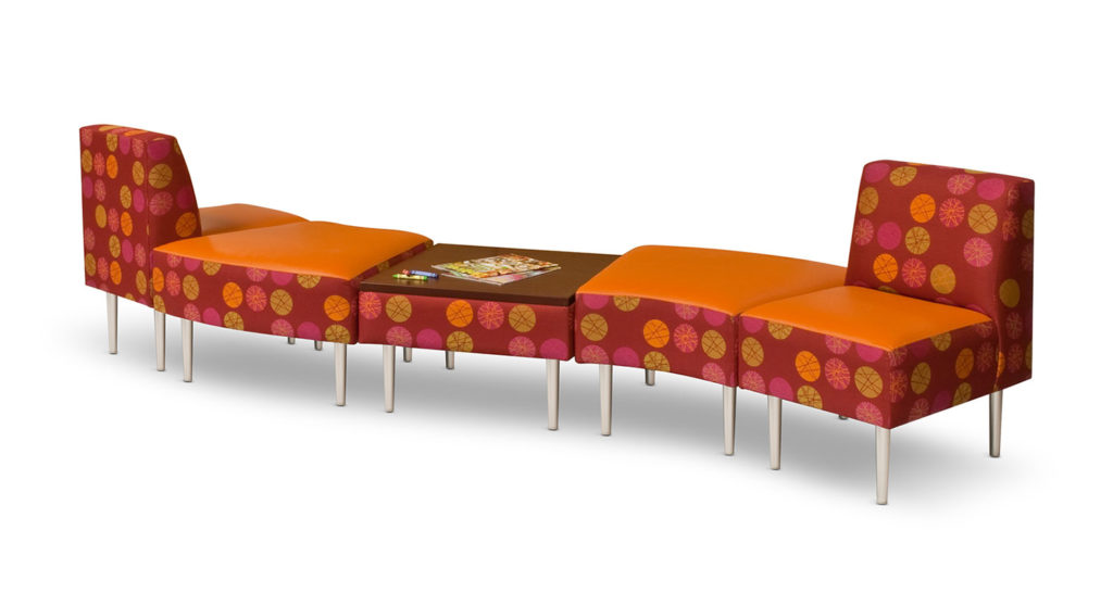 HPFI Evette Lounge Seating five units in ganged configuration with central table. Red and orange upholstery with green, orange, red, and pink polka dots. 