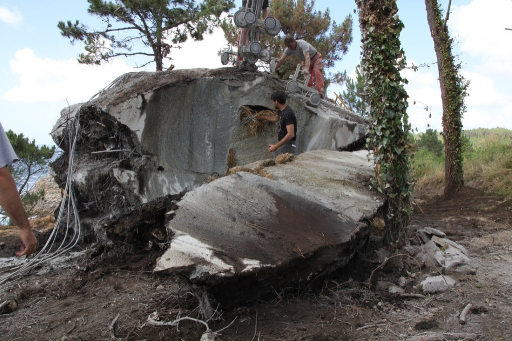 Truffle House after excavation with two men cutting hole and removing straw from interior