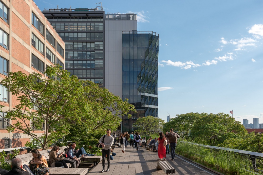 Studio Gang Solar Carve building long view with many people walking on High Line in foreground