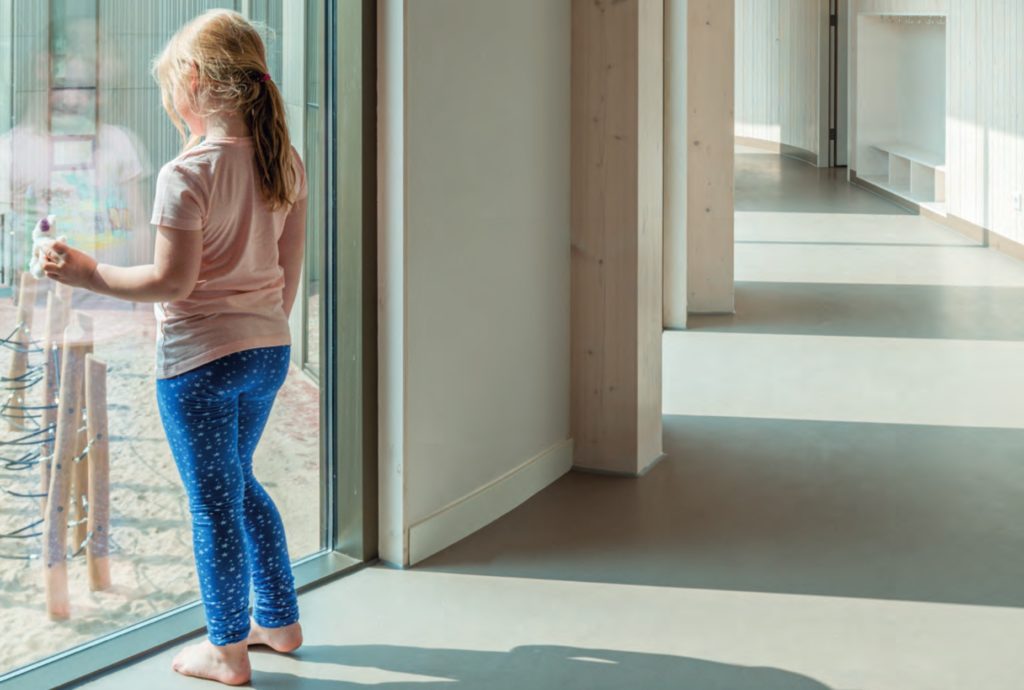 Corques Liquid Linoleum in Don Bosco school gray floor with little girl looking out window