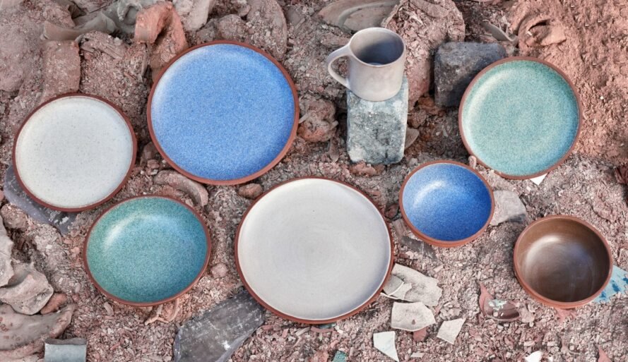 Granbyware assortment of bowls and plates and one mug on top of pile of reclaimed materials