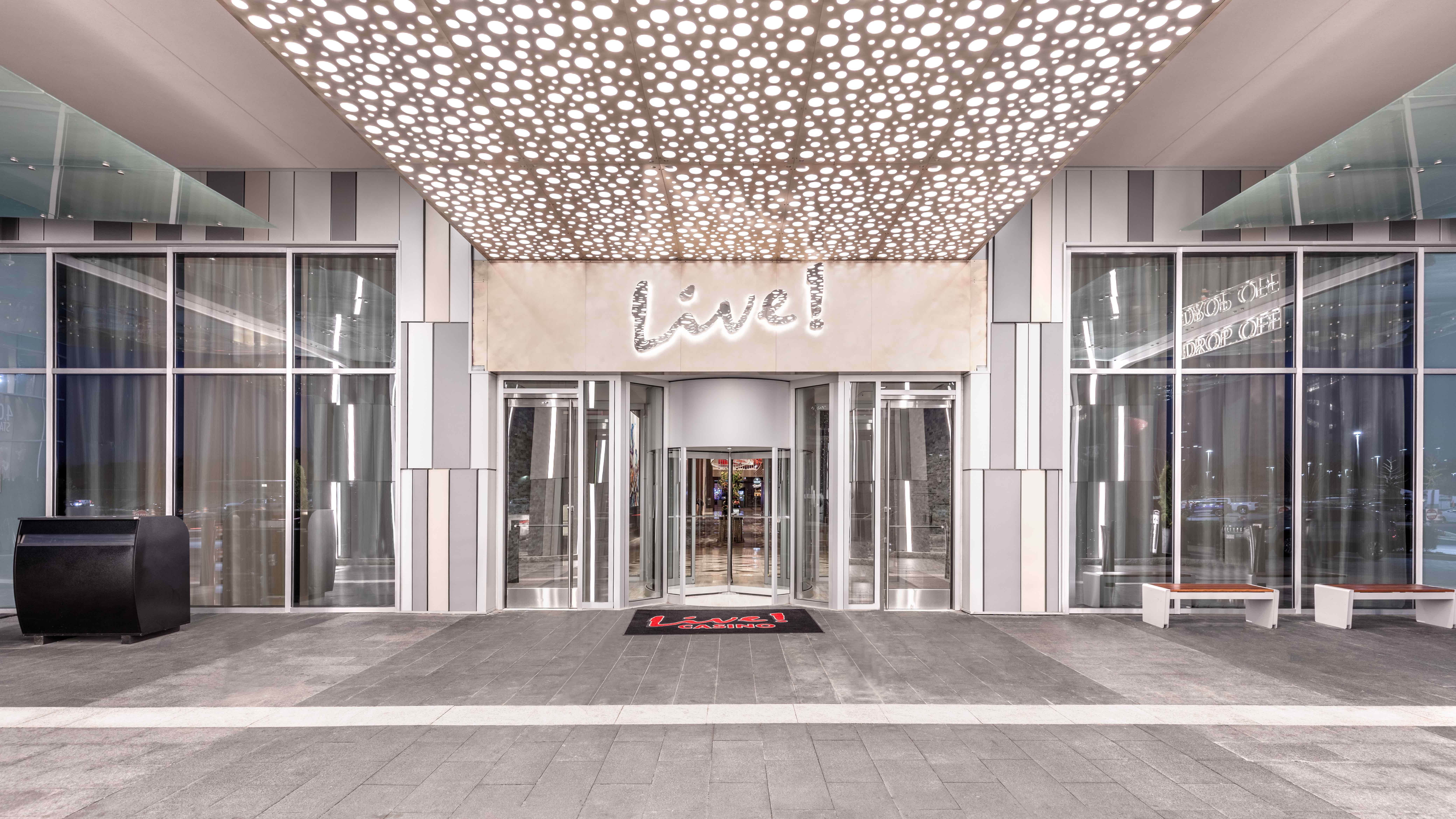 Móz Backlit Metal Solutions illuminated ceiling panel in pattern of small circles above entrance to luxury hotel