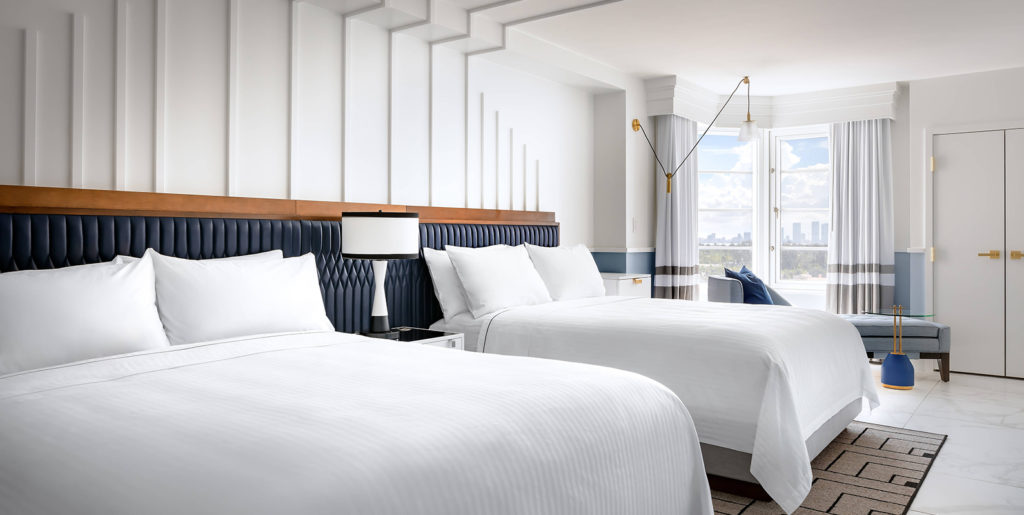 Demar Leather Cadillac Hotel and Beach Club guest room with white decor and custom black upholstered head boards