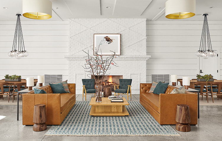 Room & Board Business Interiors Macalester Sofa in brown leather with low wood table and blue upholstered lounge seating in open room with fireplace