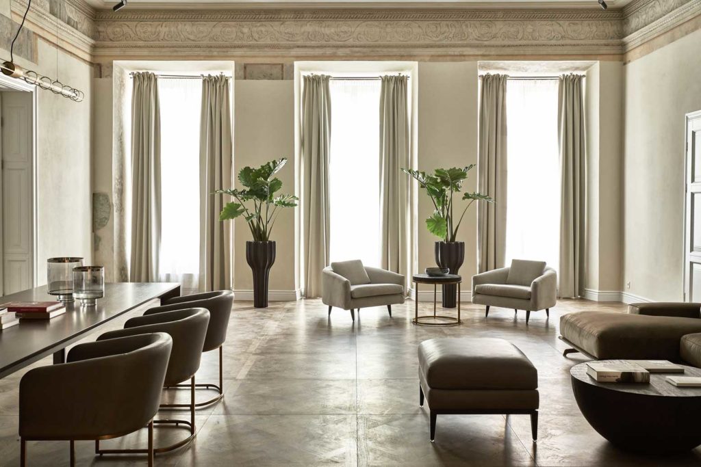 Hotel PACAI interior of suite with three large windows, marble floor, and leather lounge furniture