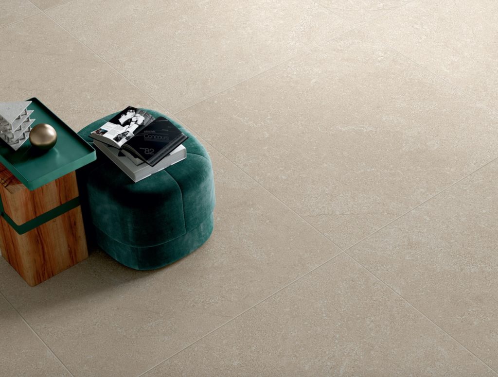 Art of Simplicity tile Alta collection detail of off-white tile with wood block table and sea-green ottoman
