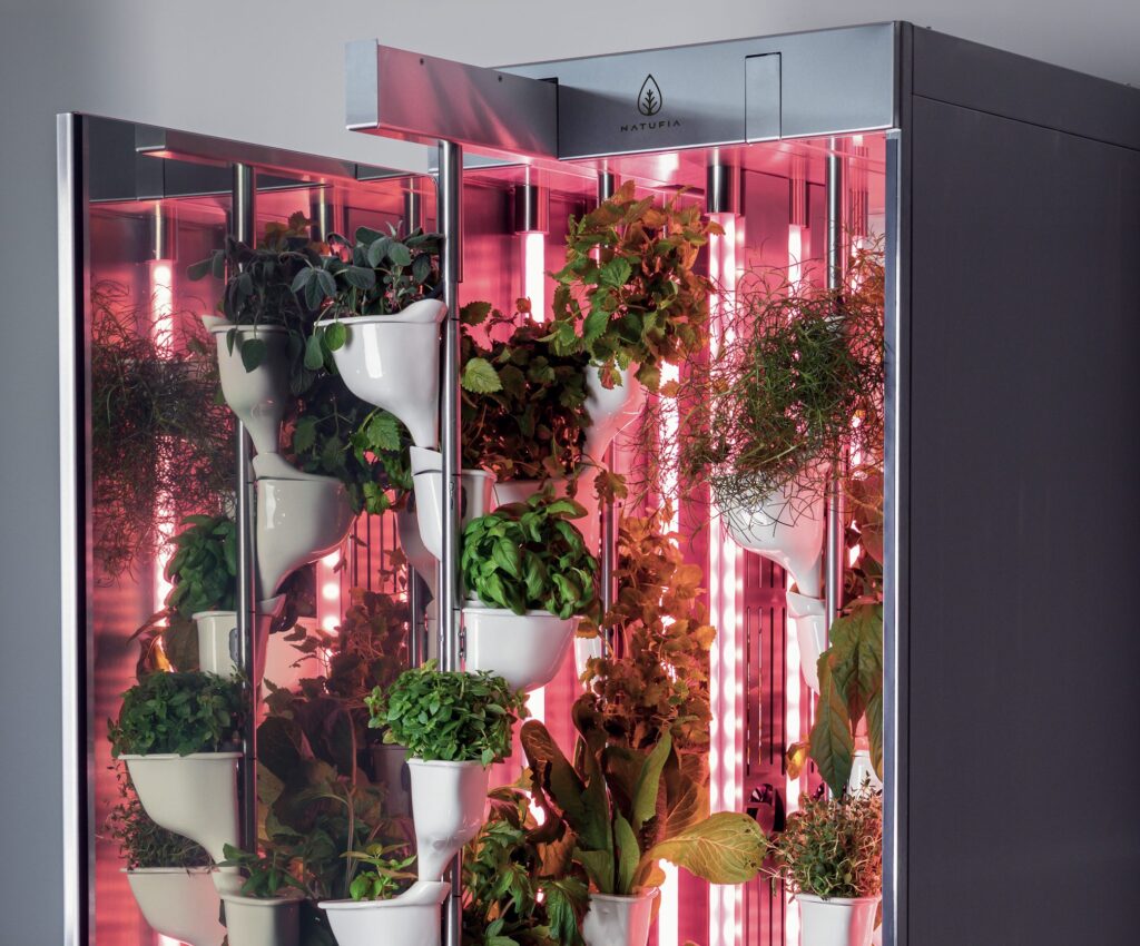 Natufia Kitchen Garden view from front with red light modules and growing plants