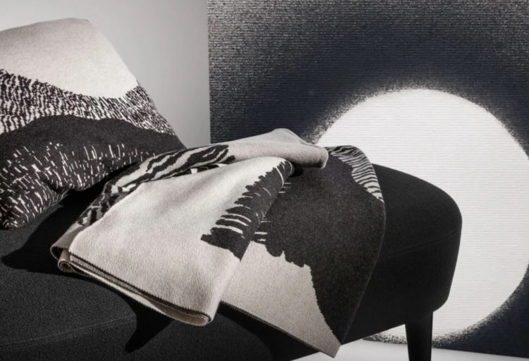 Tom Dixon Textiles Edit Dash throw and cushion on black sofa with second throw on wall nearby