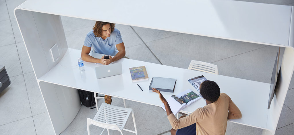 Landscape Forms' Go Outdoor Table white seated height with canopy and two people working and talking view from above