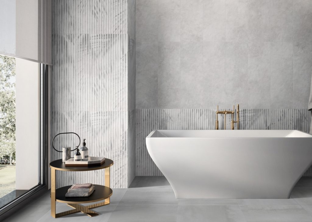 Art of Simplicity Ombra tile collection with floral pattern and vertical lines of relief in modern bathroom with geometric tub