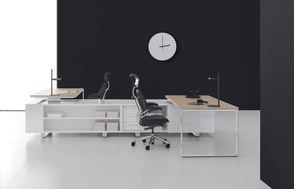 DVO Executive Office Planeta twin worktables and storage with twin black task chairs in modern office with black wall and large white clock
