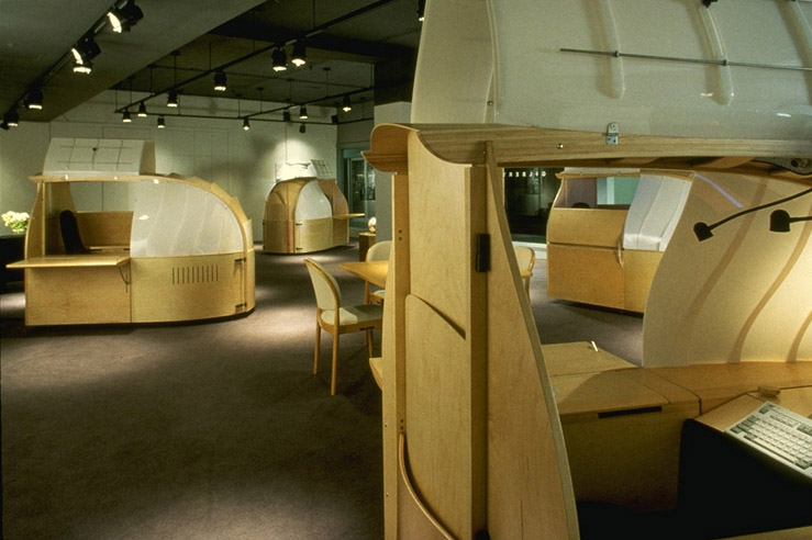 Douglas Ball Clipper work pod several clippers with different views of each in showroom. Unit features wood paneling and translucent plastic panels with interior space for sitting while doing computer work