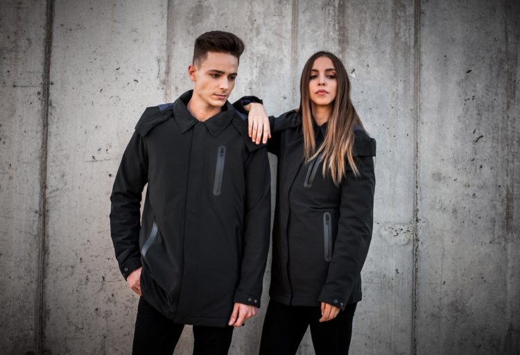 Ultra Coat medium shot of male and female models wearing coat in front of cement wall
