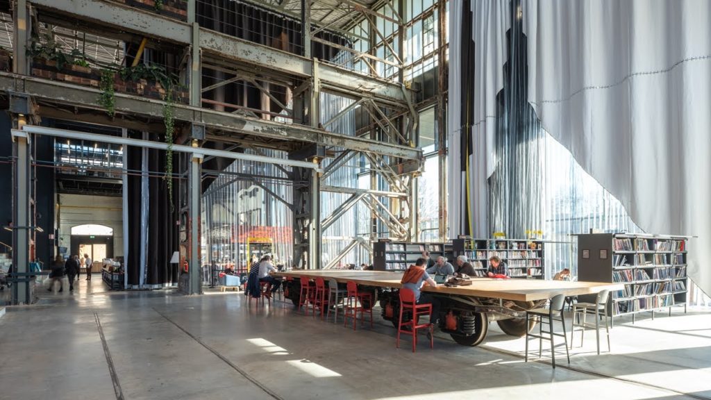 LocHal Public Library rolling tables with book stacks visible beyond