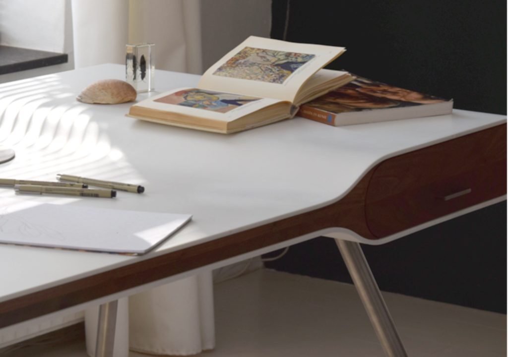 Michiel van der Kley Icon Desk partial view with American Walnut and books and pens on top of the desk 