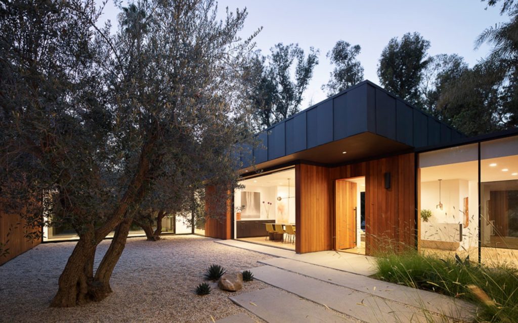Assembledge+ Laurel Hills outdoor space with gravel patio, cement pavers, and olive trees