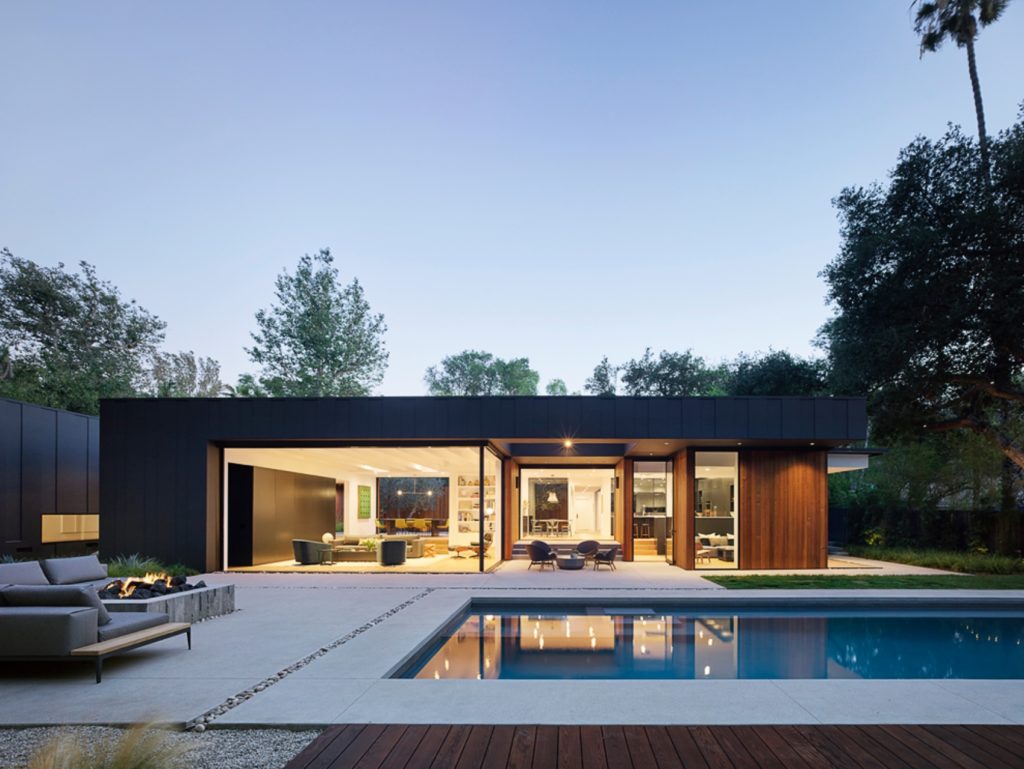 Assembledge+ Laurel Hills patio and pool area with fire feature in foreground and public pavilion with open walls in background