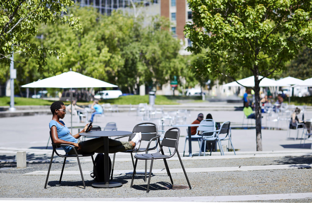 Landscape Forms 21 Chair many chairs outdoors on plaza with woman sitting with legs up
