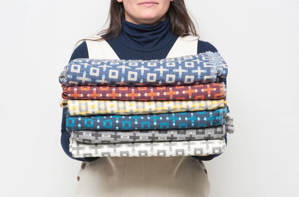 Designtex Spring Textiles Plus samples many colors held by woman