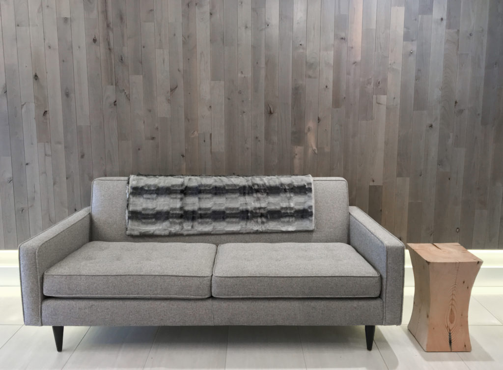 Olympia cladding sage on living room wall with couch in foreground