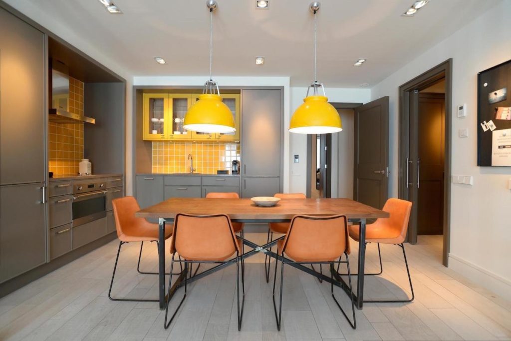 Original BTC Titan metal pendant two side by side yellow above table in apartment