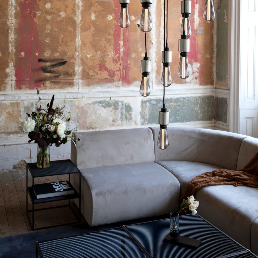 Buster Bulb smoky gray cluster of eight over a sofa with distressed wall in background
