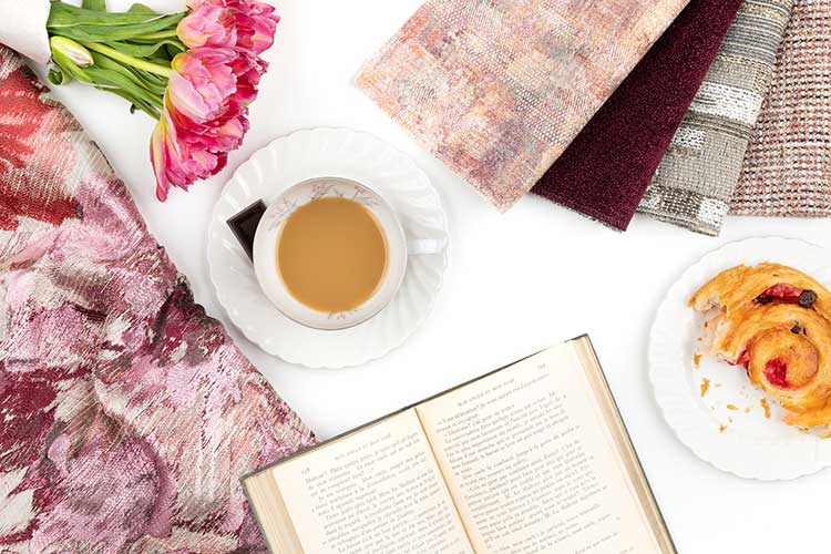 Architex Summer Textiles Left Bank swatches with coffee, danish, and book